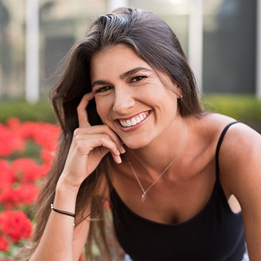 Woman with cosmetic dental bonding smiling outside