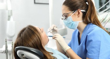 dental hygienist giving a patient a teeth cleaning in Guilderland   
