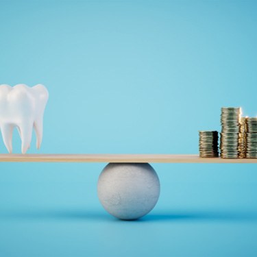 A balance beam weighing a tooth model and gold coins