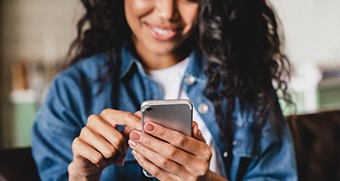 Woman smiling while looking at phone