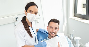 Smiling patient and dentist giving thumbs up