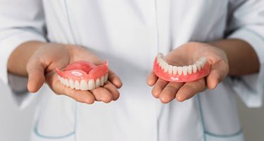 a person holding a set of dentures