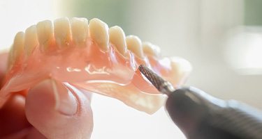 a dental tool preparing a denture