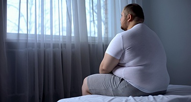 Overweight man sitting in bed