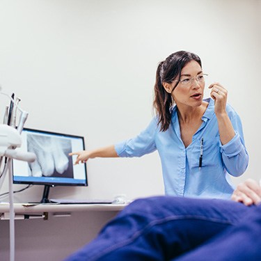 Dentist reviewing X-ray and explaining procedure to patient